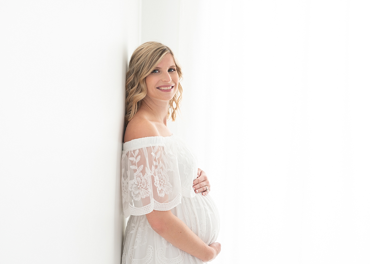 All white maternity session in light and airy photography studio in Chagrin Falls. Photos by Rachel Brookes Photography.