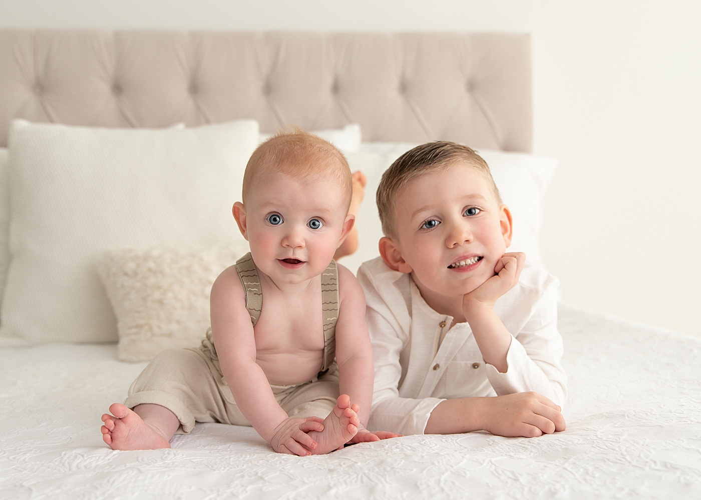 Brothers laying on a bed together for a photo with Rachel Brookes Photography.