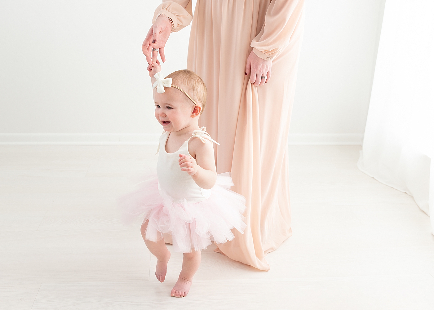 One year old girl dancing with her mom in her pink tutu. Photo by Rachel Brookes Photography.