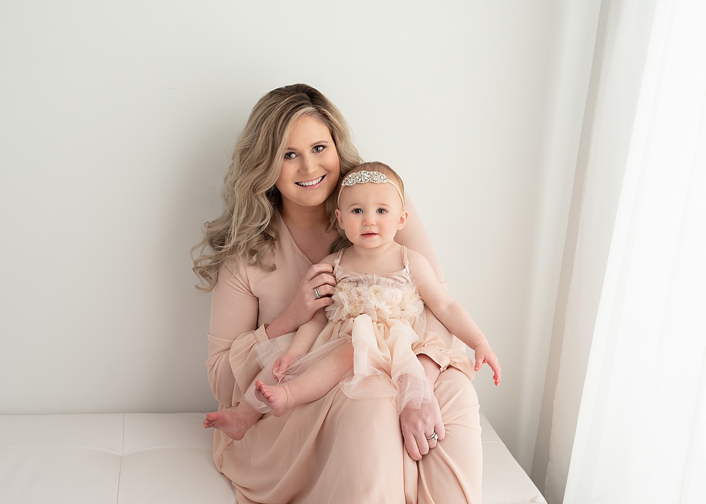 One year old baby girl and her mom sitting together for first birthday photos with Rachel Brookes Photography.