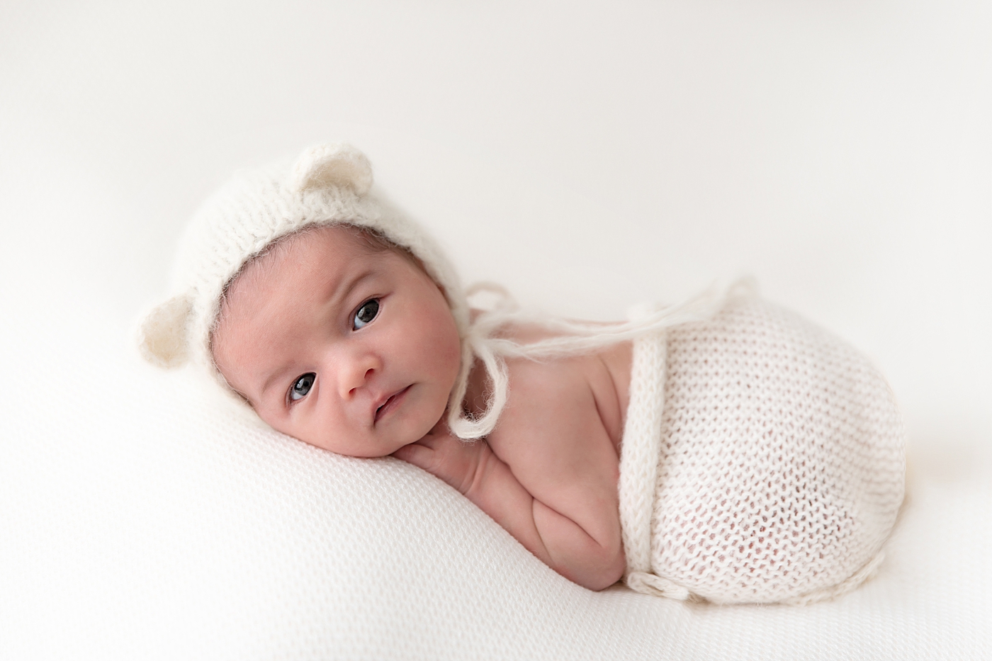 Baby boy snuggled up for his newborn photos. Photo by Rachel Brookes Photography.