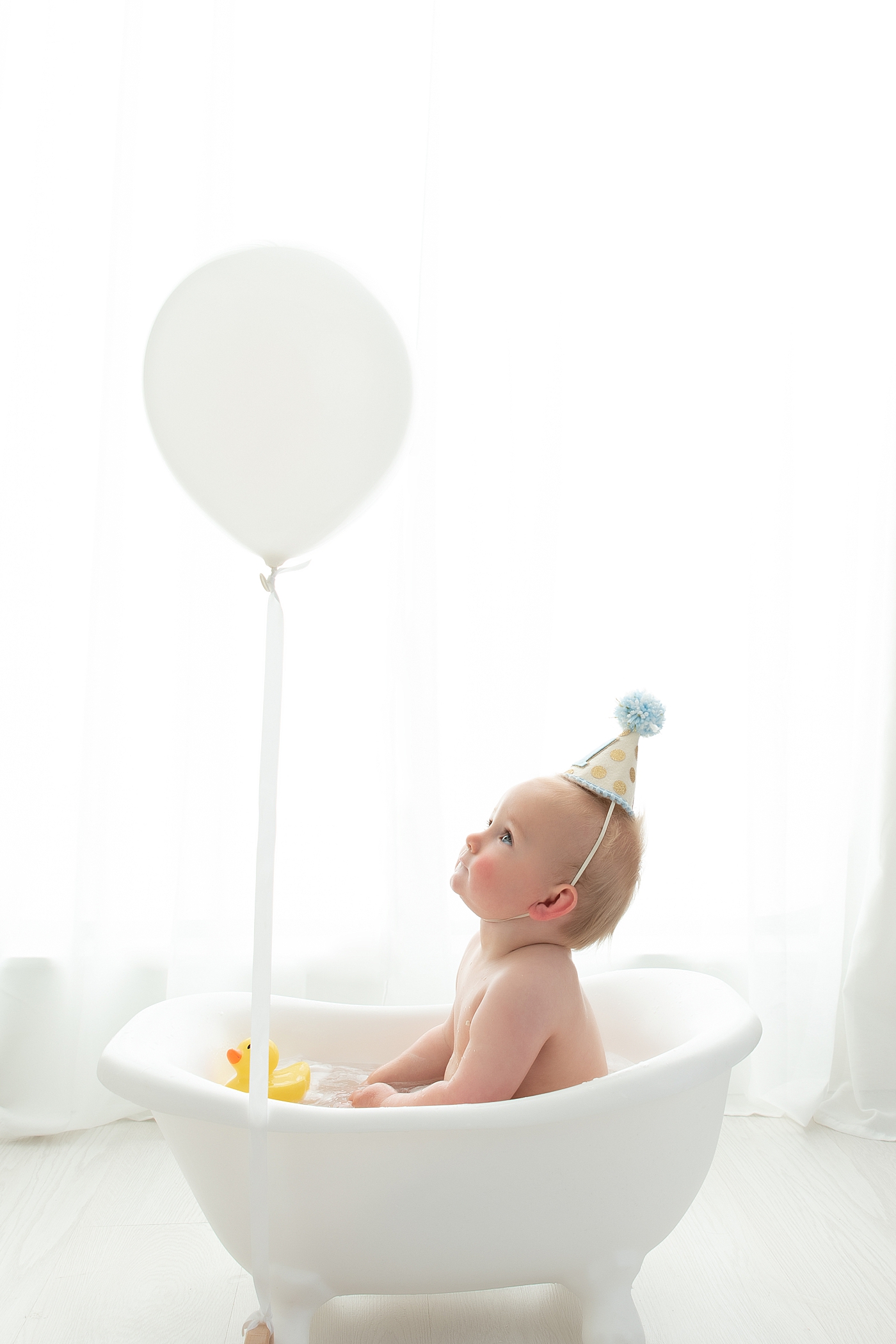 Bubble bath at the end of a cake smash session for one year old. Photo by Rachel Brookes Photography.
