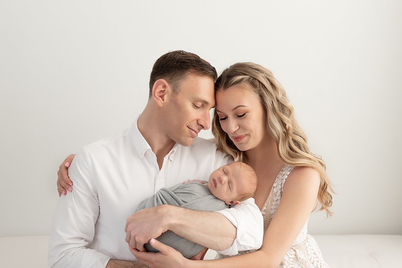 First time parents holding their newborn son for photos with Rachel Brookes Photography.